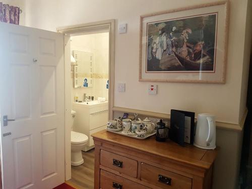 a bathroom with a sink and a toilet and a mirror at Victoria House Room Only Accommodation in Caernarfon