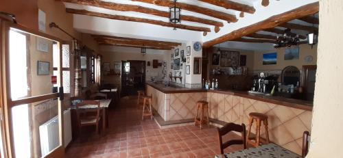 a kitchen with a counter and chairs in a room at Pensión La Fuente in Yegen