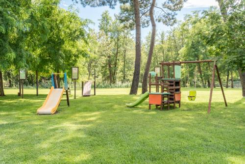 a park with several playground equipment in the grass at Hotel Stella Della Versilia in Marina di Massa