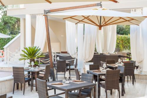 a restaurant with tables and chairs and an umbrella at Hotel Stella Della Versilia in Marina di Massa