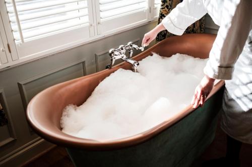 a man washing his hands in a bath tub filled with snow at Bear Of Burton in Christchurch