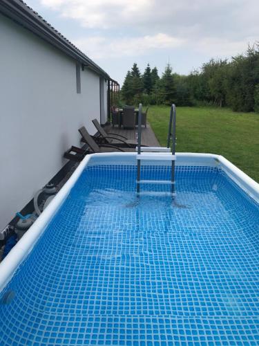 a swimming pool on the back of a house at Przytulny domek z ogrodem, parkingiem oraz innymi udogodnieniami in Malbork