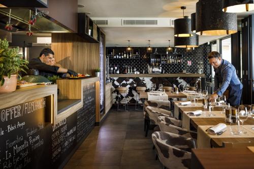a restaurant with two men standing at a counter at Girandella Resort, Valamar Collection in Rabac