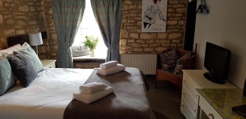 a bedroom with a bed with towels on it at The Kings Arms Hotel in Stow on the Wold
