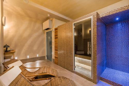 a bathroom with a shower with blue tiles at Hotel Stella Della Versilia in Marina di Massa