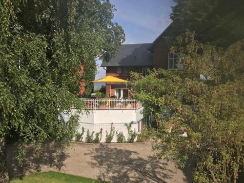 a house with a white fence in front of it at Kleines Strandhotel in Niendorf