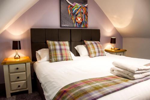 een slaapkamer met een bed en 2 tafels met lampen bij The Knowes Hotel & Restaurant in Macduff