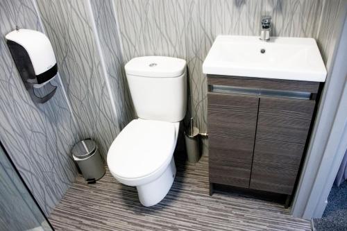 uma casa de banho com um WC branco e um lavatório. em The Knowes Hotel & Restaurant em Macduff