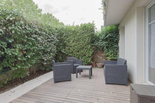 un groupe de chaises et de tables sur une terrasse dans l'établissement Garden apartment next to Disneyland, à Bussy-Saint-Georges