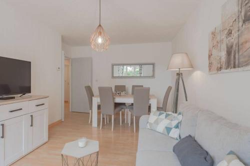 un salon avec un canapé et une salle à manger dans l'établissement Garden apartment next to Disneyland, à Bussy-Saint-Georges