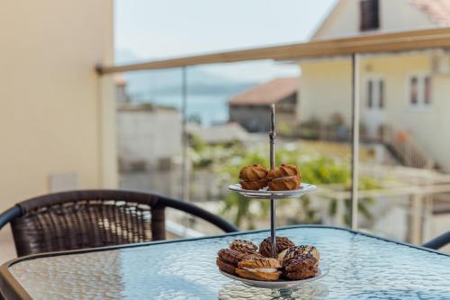 two plates of donuts on a table on a balcony at Apartments Villa Swissmonte in Herceg-Novi