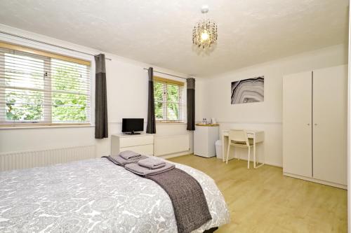 a bedroom with a bed and a desk at Harlinger Lodge Annexe in London