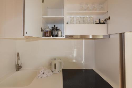 a kitchen with white cabinets and a counter top at Küüni 5B Apartment in Tartu