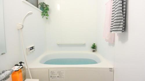 
a white bath tub sitting next to a white sink at Kyougetsu-an in Kyoto
