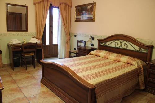 a bedroom with a bed and a desk and a table at IL Castello dei Templari in Pietrelcina