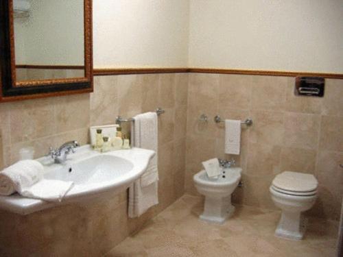 a bathroom with a sink and a toilet at Grand Hotel Palace in Marsala