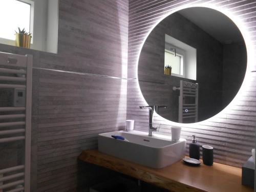 a bathroom with a sink and a mirror at La Douce Escapade in Sizun