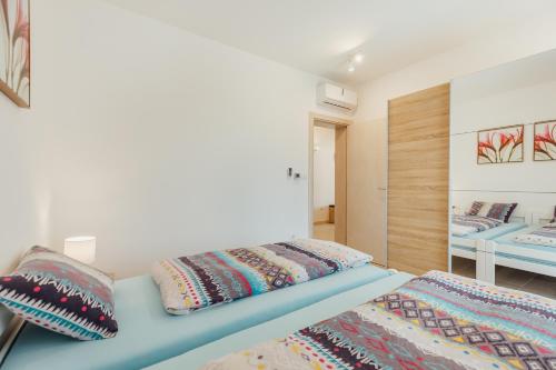a bedroom with two beds and a mirror at Apartments Villa Swissmonte in Herceg-Novi