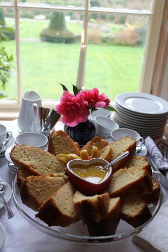 a plate of toast and bread on a table with a candle at Kilmokea Country Manor & Gardens in New Ross