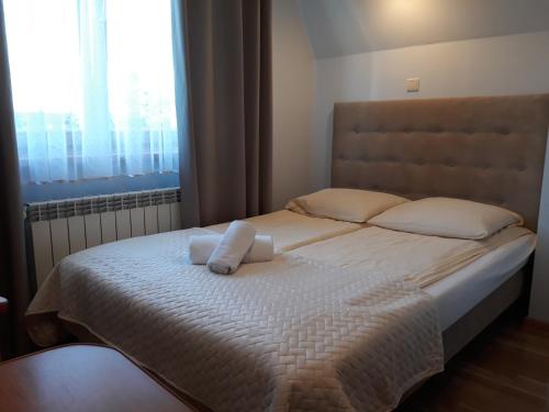 sypialnia z łóżkiem z 2 poduszkami i oknem w obiekcie Małgosia - 10 minut na piechotę do stoku narciarskiego i basenów termalnych Bania - atrakcyjny pakiet wielkanocny w mieście Białka Tatrzanska