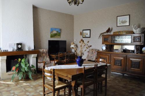 comedor con mesa, sillas y TV en Chambres d'Hotes La Mouline, en Ludon-Médoc