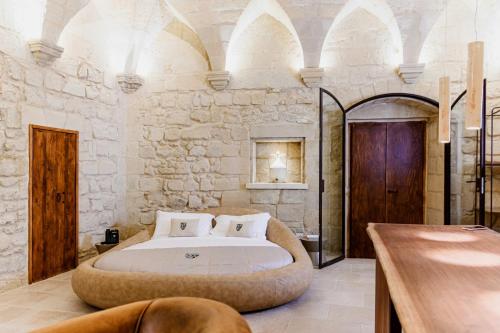 a bedroom with a large bed in a stone wall at Pollicastro Boutique Hotel in Lecce