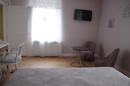 sypialnia z łóżkiem, stołem i krzesłami w obiekcie LA PART DES ANGES w mieście Mardeuil
