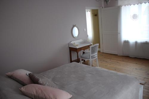 Mardeuil的住宿－LA PART DES ANGES，一间卧室配有一张床、一张书桌和一面镜子