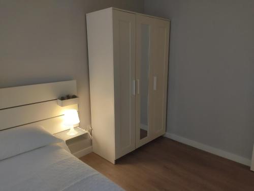 a bedroom with a bed and a closet with a lamp at Las Ildas in Anguiano