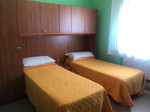 two beds in a small room with green walls at Il Portichetto in LʼAquila