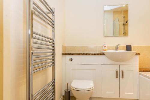 ein Badezimmer mit einem weißen WC und einem Waschbecken in der Unterkunft Guest Homes - Hillbrook House Apartment in Great Malvern