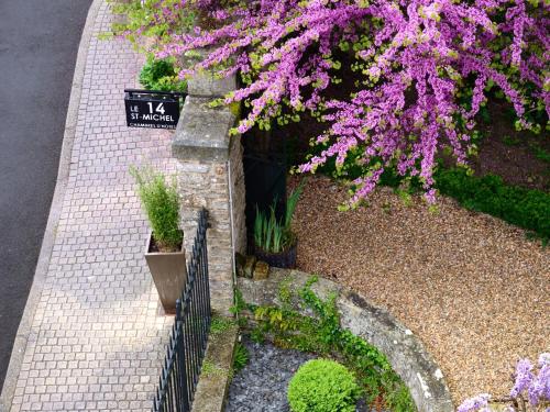 einen Bürgersteig mit lila Blumen und einem Zaun in der Unterkunft Le 14 St Michel in Josselin