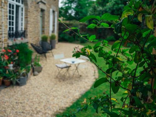 a patio with a table and chairs in a garden at Le 14 St Michel in Josselin