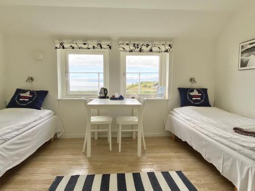 Zimmer mit 2 Betten, einem Tisch und einem Fenster in der Unterkunft Löderup Strandbad Hotell och Restaurang in Löderup