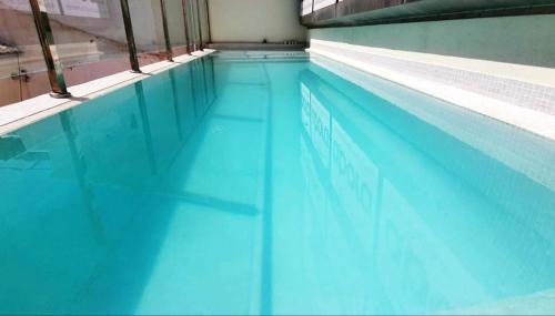 una piscina de agua azul en un edificio en ecoSmart Apartments Granada en Granada