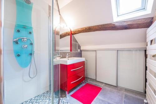 La salle de bains est pourvue d'un lavabo rouge et d'une douche. dans l'établissement Le Colombier - Magnifique Maison avec Piscine, à Montgeroult