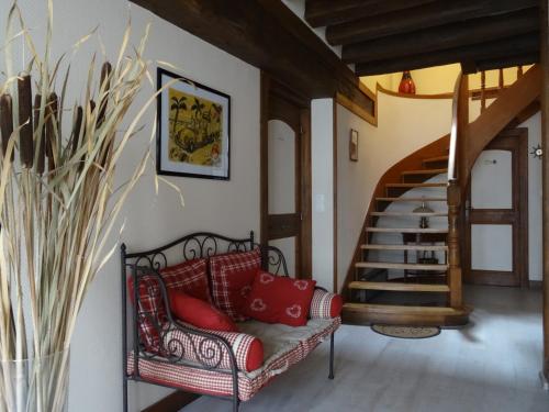 sala de estar con sofá rojo y escalera en Le Clos Elisa, en Saint Laurent Nouan