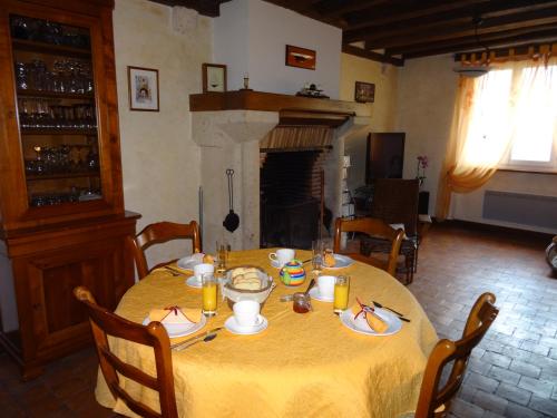 uma mesa de jantar com uma toalha de mesa amarela em Le Clos Elisa em Saint Laurent Nouan