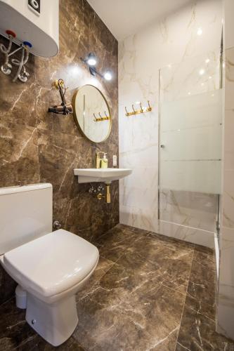 a bathroom with a toilet and a sink and a shower at DayFlat Apartments Maidan Area in Kyiv