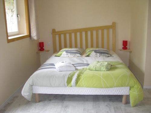 a bedroom with a bed with green and white sheets at Le Péché de Paresse in Saint-André-en-Vivarais