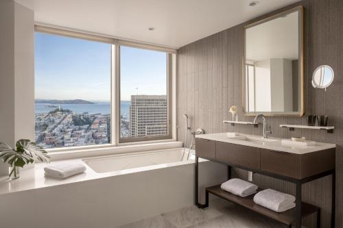 a bathroom with a tub and a sink and a large window at Four Seasons Hotel San Francisco at Embarcadero in San Francisco