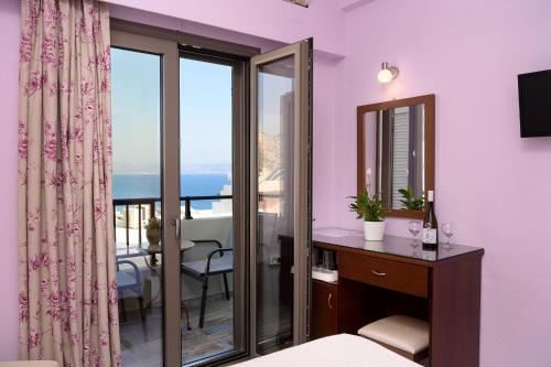 a bedroom with a room with a view of the ocean at Avra in Agia Galini