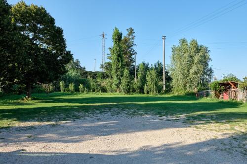 a large field with trees and a dirt road at Al Bacino Rooms And Breakfast in Porto Viro