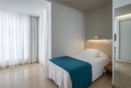 a bedroom with a bed with a blue blanket on it at Climia Belroy 4 Sup in Benidorm