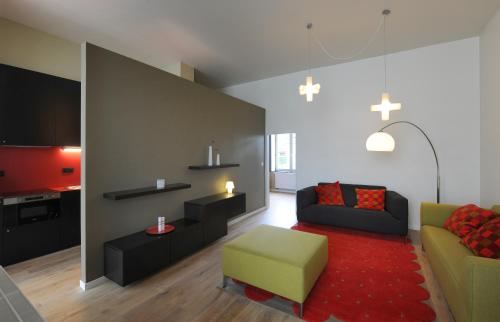 uma sala de estar com um sofá e uma cadeira em Le Presbytère em Hermalle-sous-Huy