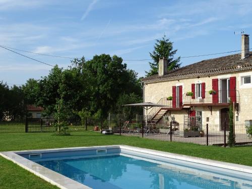 a swimming pool in the yard of a house at LE RELAIS D'ARZAC in Cahuzac-sur-Vère