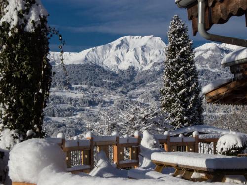 pokrytą śniegiem ławką z widokiem na góry w obiekcie Les Greniers du Mont Blanc w mieście Passy