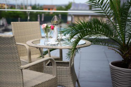 a table and chairs with flowers on a balcony at MELISS EVENTS in Craiova