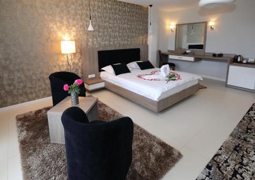 a bedroom with a bed and chairs in a room at MELISS EVENTS in Craiova