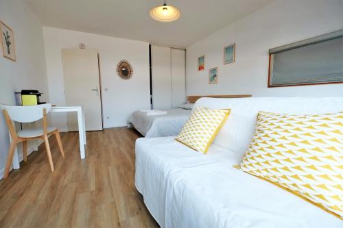 - un salon avec un canapé blanc et un bureau dans l'établissement Les Studiantes - T1 32 m² hypercentre gares/métro, à Lille